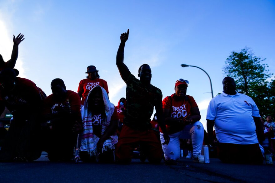 People pray yesterday outside the scene of Saturday's shooting at a supermarket, in Buffalo, N.Y.