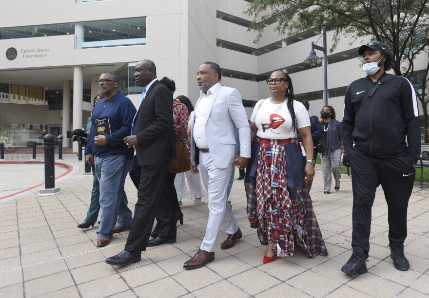 Attorney Ben Crump, second from left, walks with Ron Lacks, left, Alfred Lacks Carter, third from left, both grandsons of Henrietta Lacks, and other descendants of Lacks, outside the federal courthouse in Baltimore, Oct. 4, 2021. The family of Henrietta Lacks is settling a lawsuit against a biotechnology company it accuses of improperly profiting from her cells. Their federal lawsuit in Baltimore claimed Thermo Fisher Scientific has made billions from tissue taken without the Black woman’s consent from her cervical cancer tumor.