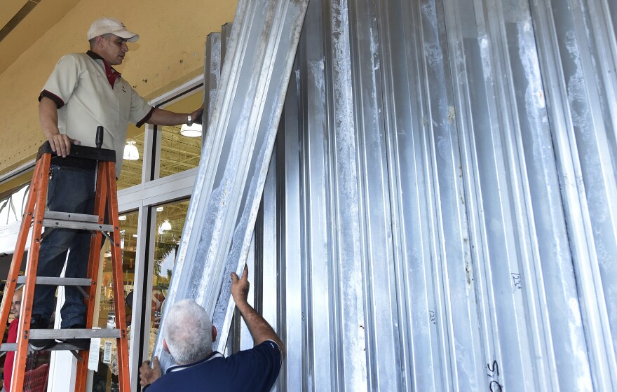 Workers put up shutters at a strip mall in preparation for Hurricane Matthew in Miami on Thursday. Some 3 million people on the Southeast coast faced an evacuation order.