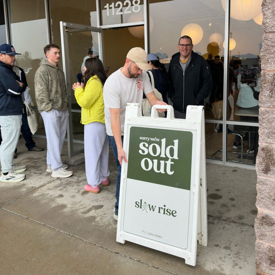 Owner Jeff Dunkel places a “sold out” sign outside Slow Rise in Overland Park during a busy morning in February.