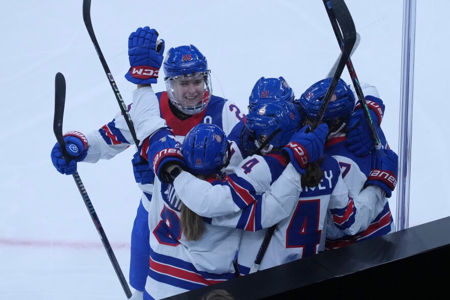 United States' Caroline Harvey celebrates with teammates after scoring her side's first goal during a preliminary round match of women's ice hockey between USA and Canada at the 2026 Winter Olympics, in Milan, Italy, Tuesday, Feb. 10, 2026.