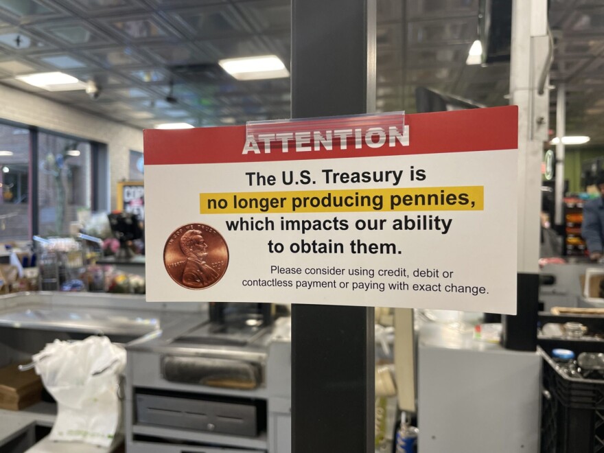 A sign posted in a Needlers grocery store in downtown Indianapolis asks customers to pay by card or with exact change, citing a penny shortage spurred by the end of penny production, on Monday, Dec. 29, 2025.