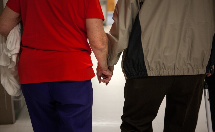 Cavell holds his wife Hilda's hand during a visit to the VA facility in Richmond, Va., in May 2015 for a series of exams to re-evaluate whether he can qualify for disability benefits after being exposed to mustard gas testing during his time in the military.