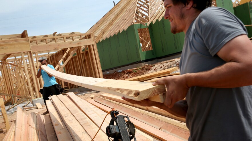 Max Alvarez (left) and Hollan Corliss construct a new home in Moore, Okla., to replace one that was destroyed in May 2013. More than 300 new homes have been built since the tornado, in addition to the 1,100 that are being rebuilt.