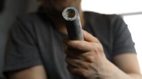 Troy Hernandez, an environmental justice activist with Pilsen Environmental Rights and Reform Organization shows a piece of lead pipe obtained from his residence during his home renovation, Friday, April 9, 2021 in Chicago's Pilsen neighborhood. Hernandez recently spent $15,000 to replace the lead service lines bringing water into his home. (Shafkat Anowar/AP)