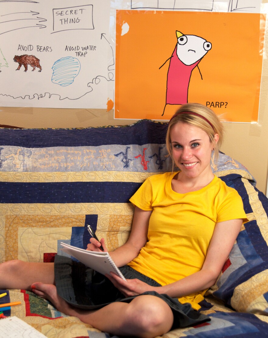 <em></em> <em>Hyperbole and a Half</em> is Allie Brosh's first book. In it, as on her blog, she draws herself with a tube body and a yellow, triangle ponytail.