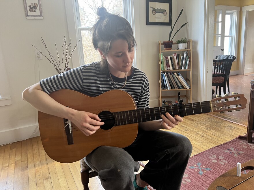 Louisa Stancioff playing her guitar at her home in Warren, Maine