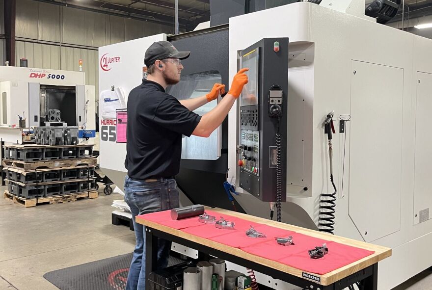 A Jupiter employee making parts with a Computer Numerical Control machine.