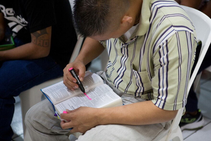 A former gang member highlights a Bible passage during a service at Eben-ezer.