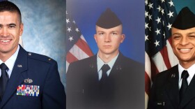 Three men wearing U.S. Air Force uniforms, with U.S. flags behind them.