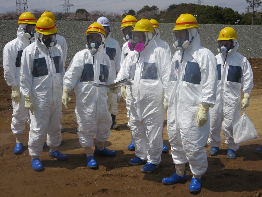 As they inspected an underground storage pool near the crippled Fukushima Daiichi nuclear power plant earlier this month, Tokyo Electric Power Co. President Naomi Hirose (4th from left) and other officials wore protective suits and masks. Radioactive water stored in some of the pits has leaked.