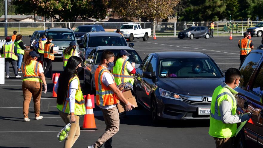 Food is loaded as drivers in their vehicles wait in line at a food distribution hosted by the Los Angeles Food Bank on Dec. 4 in Hacienda Heights, Calif.