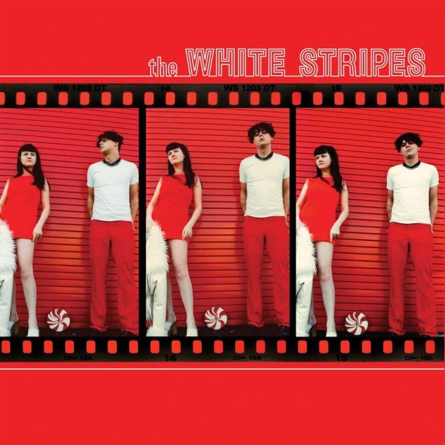 two people with a red background looking at camera 