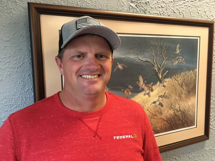 Photo of Paola, Kansas, resident and world champion shotgun trap shooter Derrick Mein, wearing a hat and red shirt.