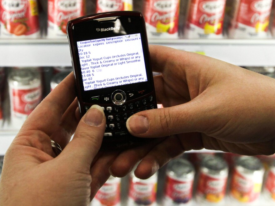 A shopper searches on her BlackBerry for coupons inside a Target store. Consumers with smartphones are changing the way stores set prices and track customer tastes.