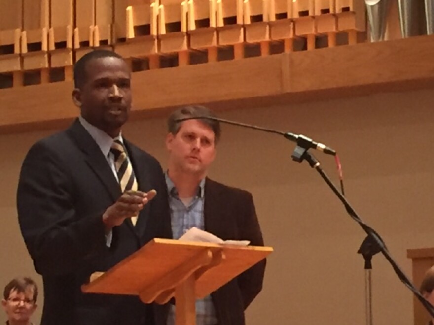 Two men, one at podium in a church