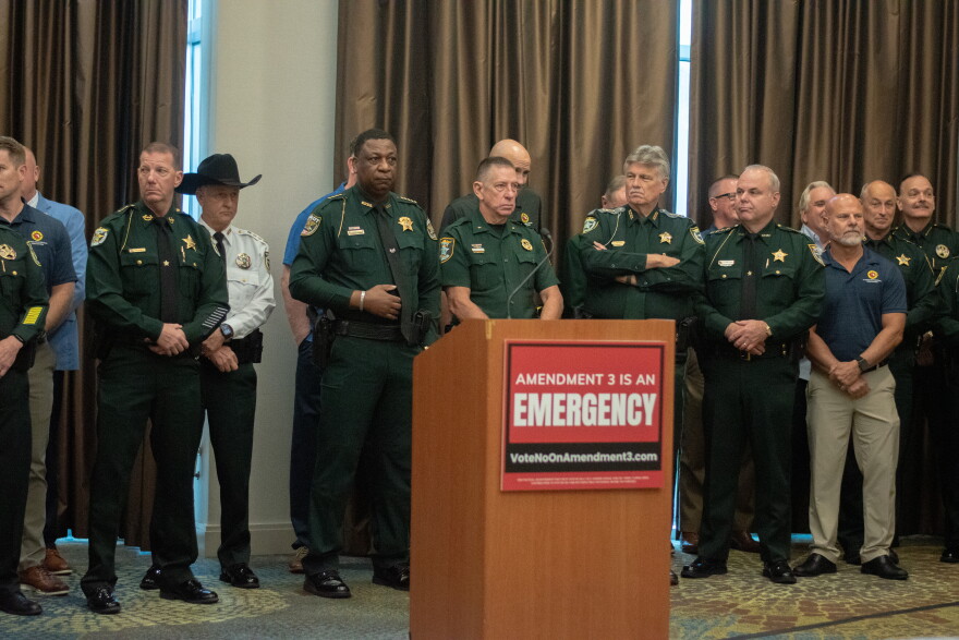 Public safety personnel line the walls of a conference room as law enforcement and fire officials gathered to speak about the potential impact of Amendment 3 on local public safety funding.