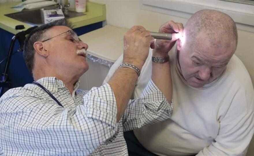 Dr. David Mathis examines the ear of an inmate at the California Medical Facility in Vacaville in 2012. California is one of at least 38 states that authorize the collection of medical fees from inmates.