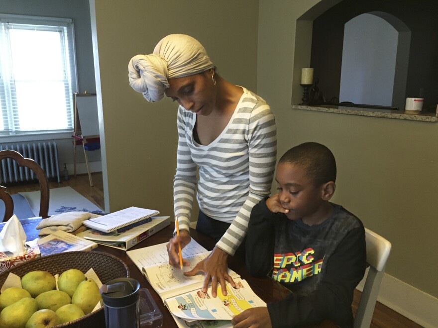 Camille Kirksey helps Brandon with math at the dining room table. Kirksey says black children at Brandon's private pre-K weren't given the kindness she thought they needed, so she decided to home-school him.