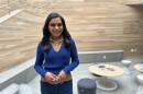 Mindy Kaling stands in the lobby of the Hopkins Center for the Arts wearing a blue sweater.