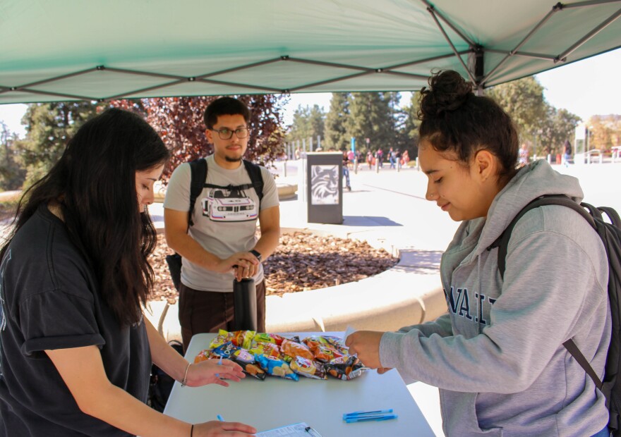 Verania Vizcarra-Sanchez, left, President of the UC Merced chapter of the Young Democrats, said the number of students her organization registers to vote varies. On a recent Tuesday morning, the tent registered only one student.