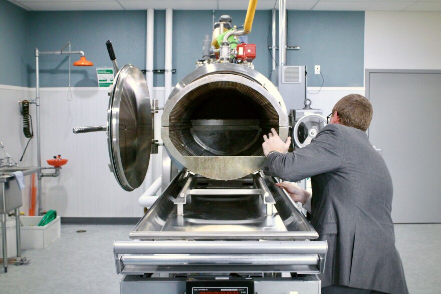  Ren Scherling, a funeral director at Goes Funeral Home, demonstrates the loading process for water cremation. The machine uses water and potassium hydroxide to reduce a body to bones, a process called alkaline hydrolysis.