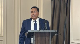 Man in blue suit and white shirt at podium