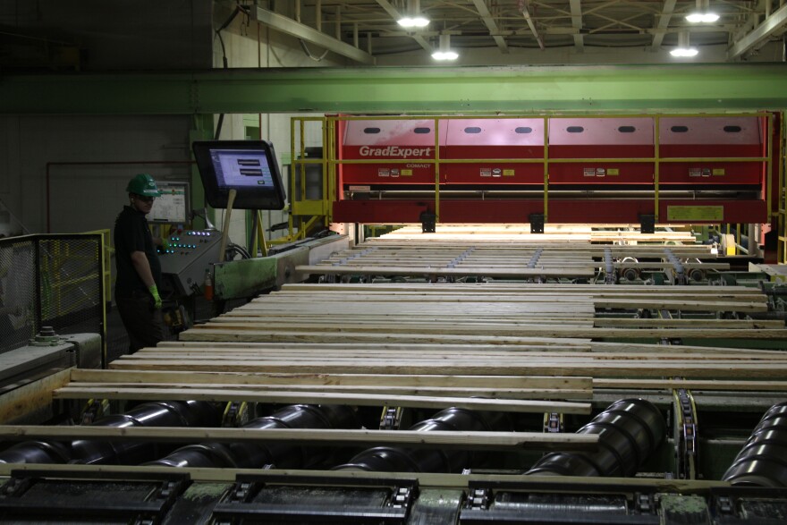 Boards moving along a conveyor system at the Irving sawmill in Ashland. Amid staffing shortages, the company is recruiting workers from as far away as Texas and Louisiana.