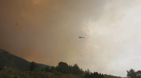 A helicopter carrying water to the Plaskett Fire.