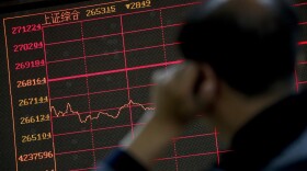 An investor monitors shares prices in front of an electronic board displaying the Shanghai Composite index at a brokerage house in Beijing, Monday, Sept. 17, 2018. Asian shares were mostly lower Monday on reports that President Donald Trump will soon place tariffs on $200 billion more of Chinese goods, even as officials worked to iron out tensions between the world's two largest economies. (AP Photo/Andy Wong)