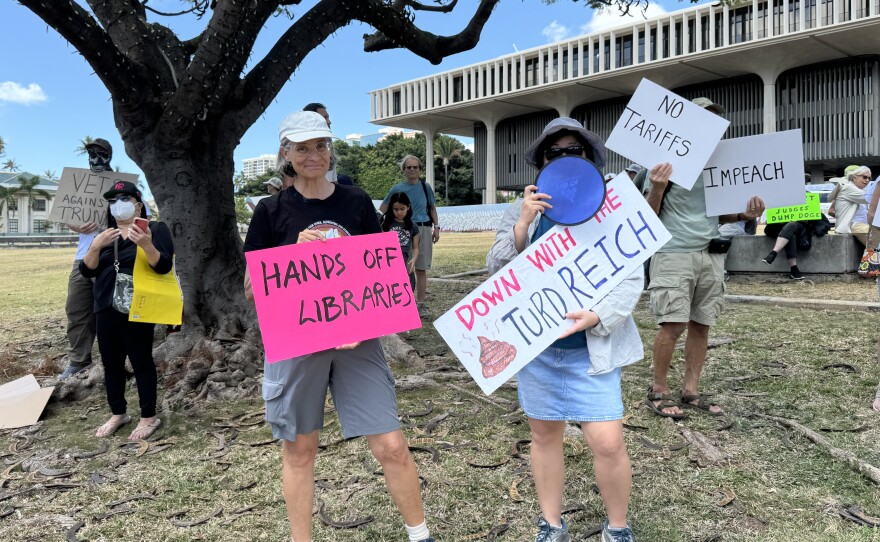 A group of protesters outside the state Capitol building wave their signs at the Hands Off Rally.