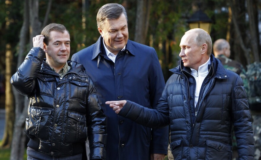 Ukrainian President Viktor Yanukovich (center) meets with Russian leaders Dmitry Medvedev (left) and Vladimir Putin outside Moscow in 2011. Yanukovich had warm relations with Russia, but was ousted amid mass protests in February 2014. Shortly afterward, Putin sent Russian troops into Ukraine, where they seized Crimea.