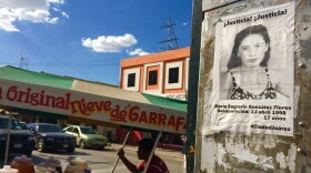 A missing woman's flyer on a wall while a vendor walks past