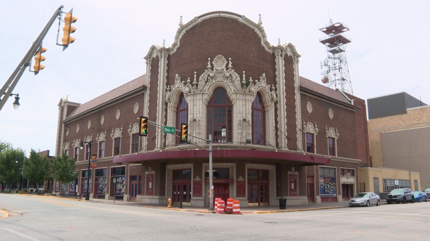A historic theater on a corner spot on a road.
