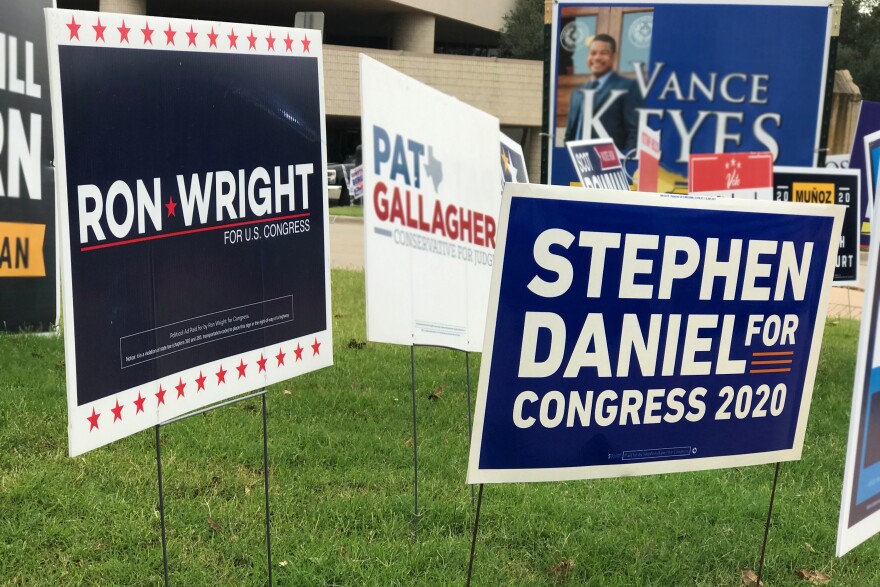 Campaign signs for Ron Wright, which is dark blue with white block letters and red stars, and Stephen Daniel, a lighter blue with white block letters, are stuck in the ground amid an array of other signs for politicians running for elected office in Mansfield.