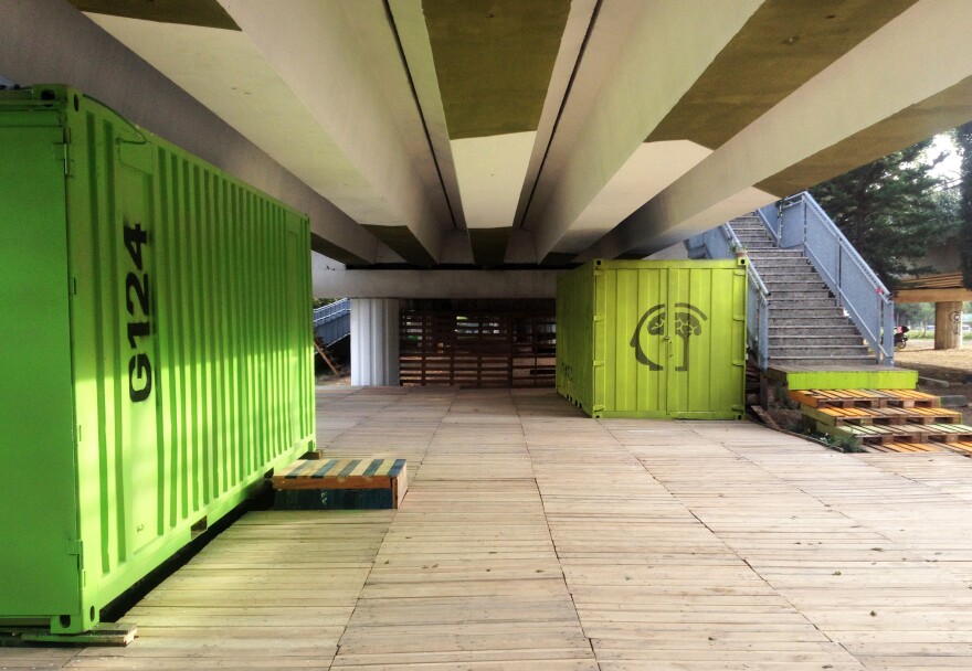 A team of architects has cleaned up the garbage below the tracks and — using shipping containers and other recycled containers — have transformed a planned tram stop into a community space.