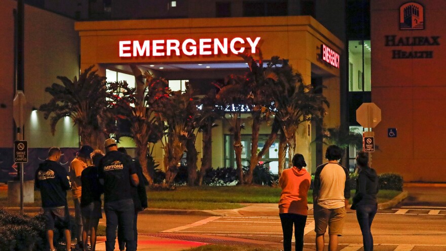 Race fans wait outside the emergency room of Halifax Health Medical Center where Ryan Newman was taken after he was involved in a crash during the final lap of the NASCAR Daytona 500 auto race at Daytona International Speedway, Monday, Feb. 17, 2020, in Daytona Beach.
