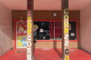 The storefront of The Popcorn Corner in downtown Columbia. The windows have popcorn decorations on them and there are two brick pillars in front with the words "The Popcorn Corner Co." 