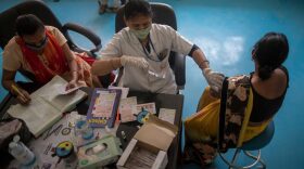 Medical worker inoculates a woman with the jab of Covid-19 coronavirus vaccine at a district hospital in the outskirts of New Delhi, India.