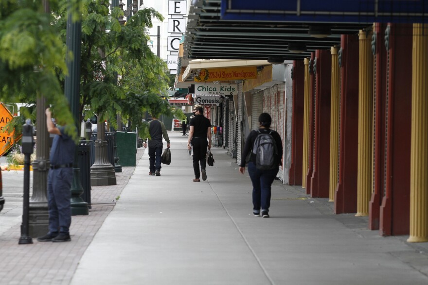 Sergio Soriano, 33, of Ciudad Juarez, Mexico, looks at shuttered shops as he walks to work downtown Friday, May 1, 2020, in El Paso, Texas, after crossing through customs.