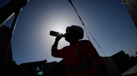 A worker drinks water on a construction site during high temperatures Wednesday, June 24, 2026. (AP Photo/Christophe Ena)