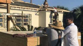 Contractors replace a roof on a Panama City resident's home almost one year after Hurricane Michael devastated the region. (Valerie Crowder/WFSU)