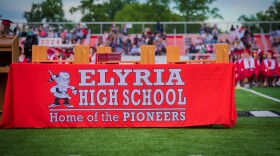 A banner at a 2024 graduation ceremony for Elyria High School students.