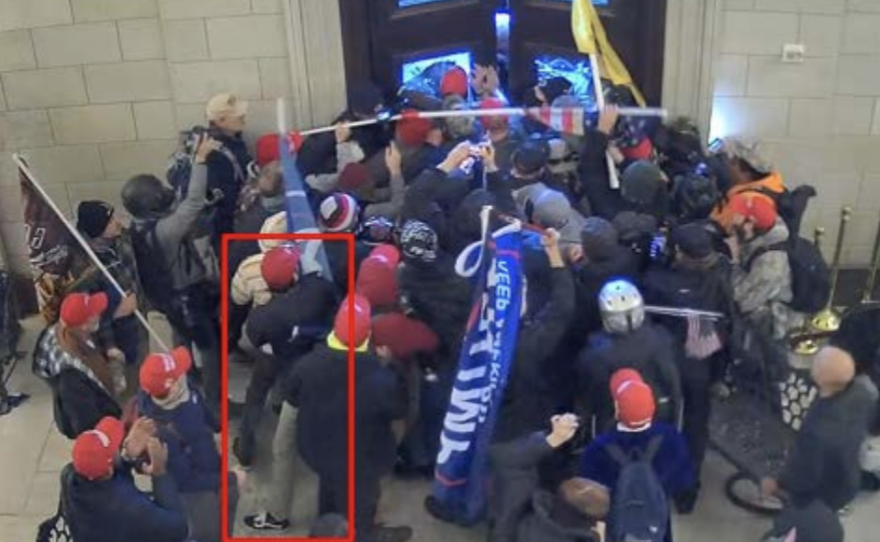 The Justice Department says Christian Secor can be seen in surveillance footage from inside the U.S. Capitol on Jan. 6. Charging papers include this screen grab, allegedly showing Secor pushing against Capitol Police officers along with other members of the mob.