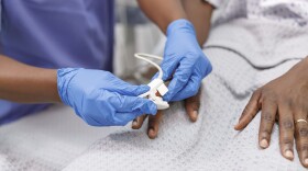 Nurse using pulse oximeter on hospitalized patient