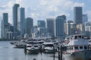 Many boats at a marina are in the foreground, and in the background, the Miami skyline.