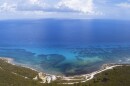 An aerial view of Mahahual shows the close relationship between the Caribbean Sea, coastal mangroves, and the Mesoamerican Reef System. The landscape highlights the fragile balance between marine and terrestrial ecosystems that defines the region.