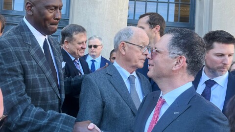 Michael Jordan, left, shakes hands with NASCAR attorney Lawrence Buterman as NASCAR chairman Jim France, center, looks away, Thursday, Dec. 11, 2025, outside the federal courthouse in Charlotte, N.C.