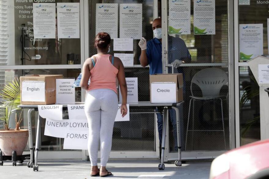 A woman asks for an unemployment form at a Miami library during the coronavirus pandemic in April.
