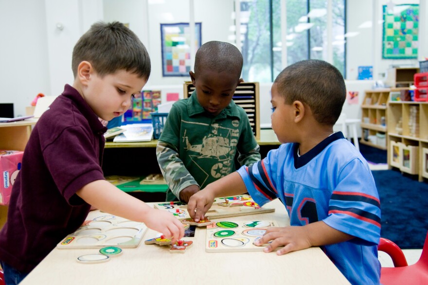 Three boys playing at a preschool.